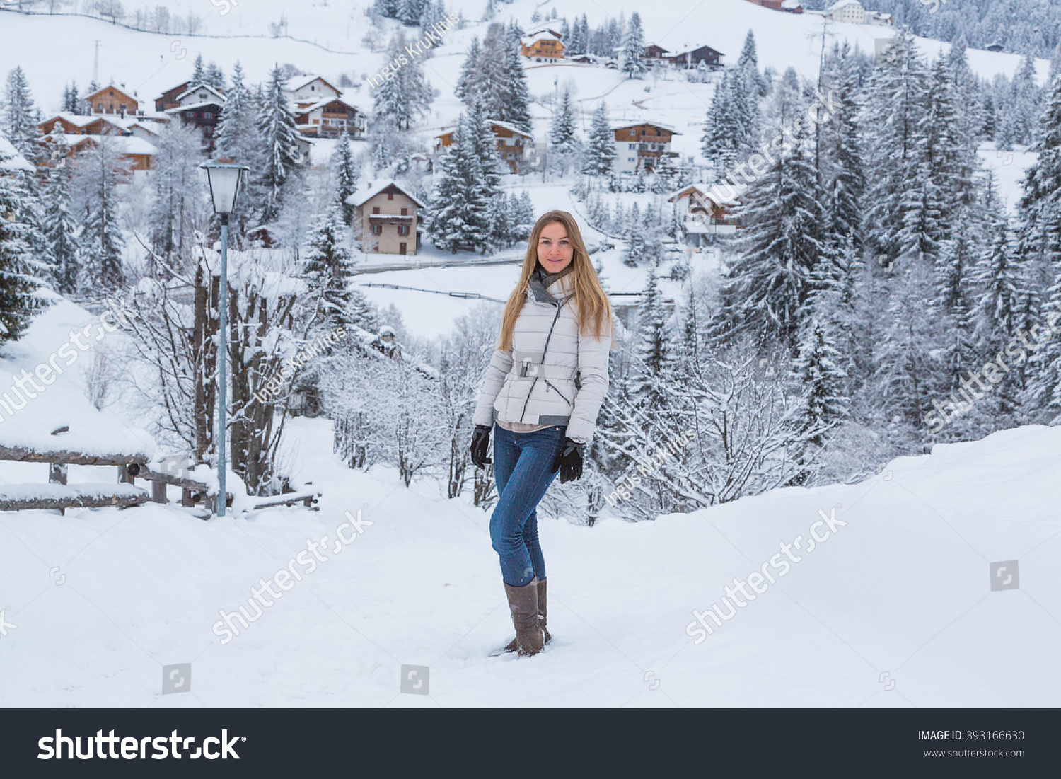 stock-photo-beautiful-girl-standing-in-the-snow-by-the-road-in-a-mountain-village-with-an-amazing-nature-view-393166630.jpg