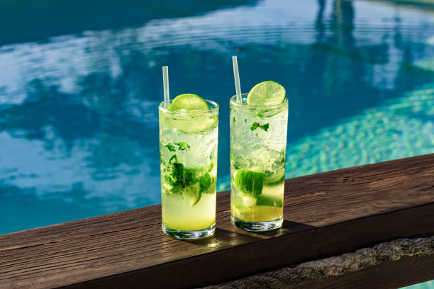 two-fresh-and-cold-mojitos-with-ice-cubes-lime-slices-and-mint-leaves-picture-id1212172937